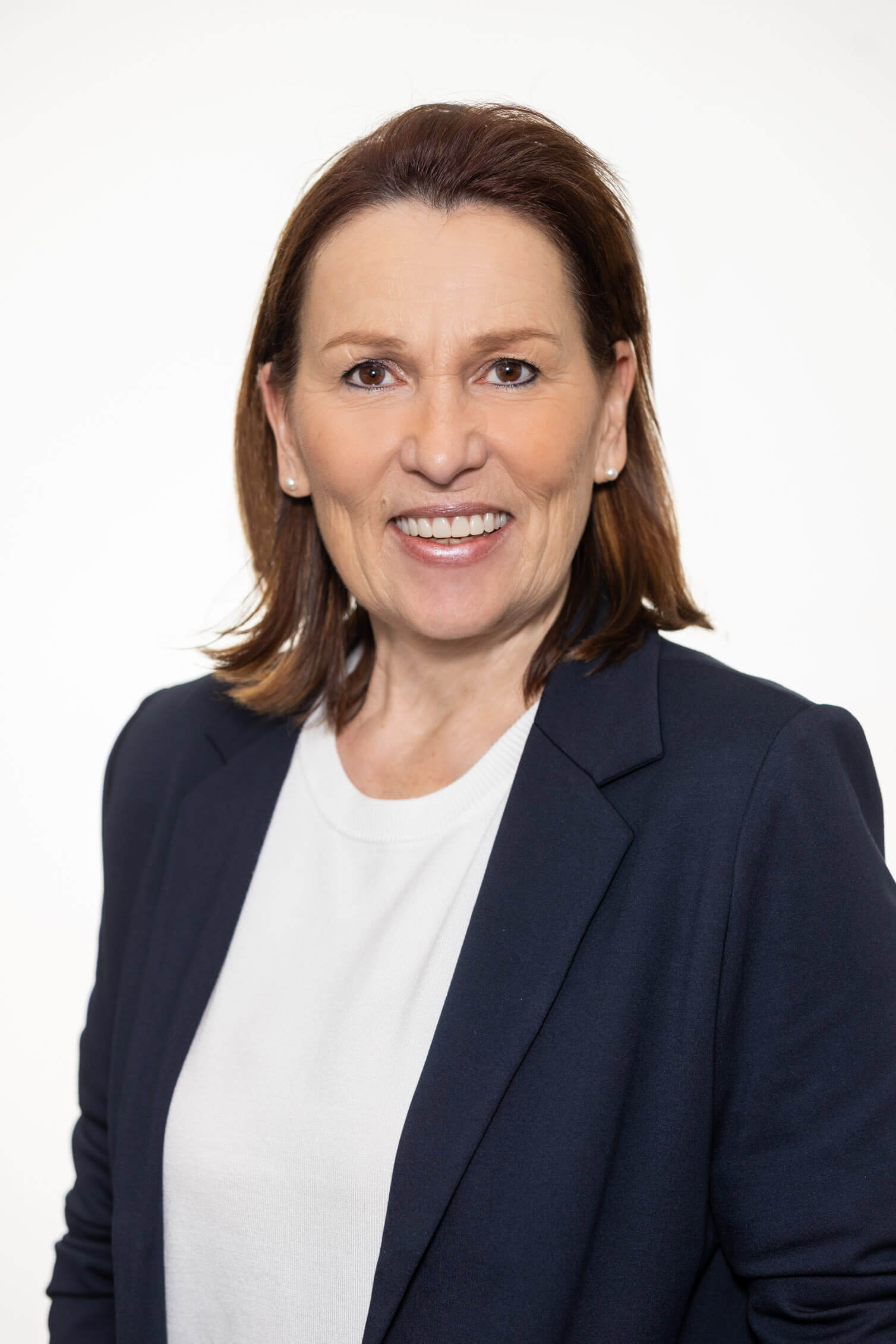 Frau Hirnschall mit Perlenohrringen, weißem Shirt und dunkelblauem Blazer, Killer Entsorungsfirma