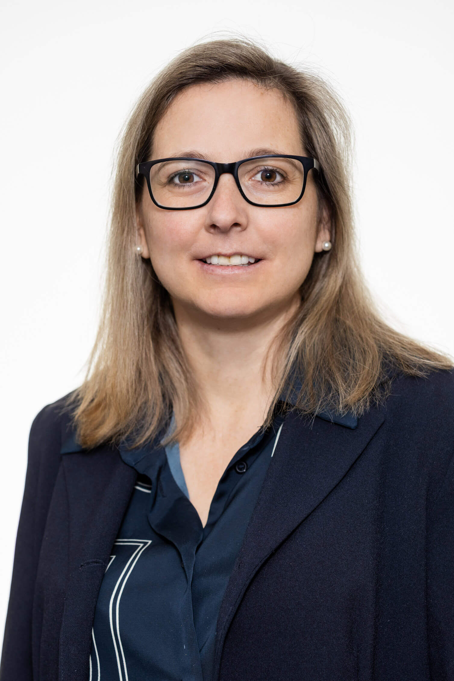 Frau Holzinger mit Brille und schulterlangem Haar in dunkelblauer Bluse und Blazer, Killer Entsorungsfirma